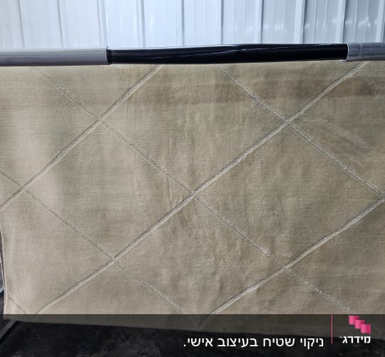 שטיח תלוי לייבוש על מתקן מתכת